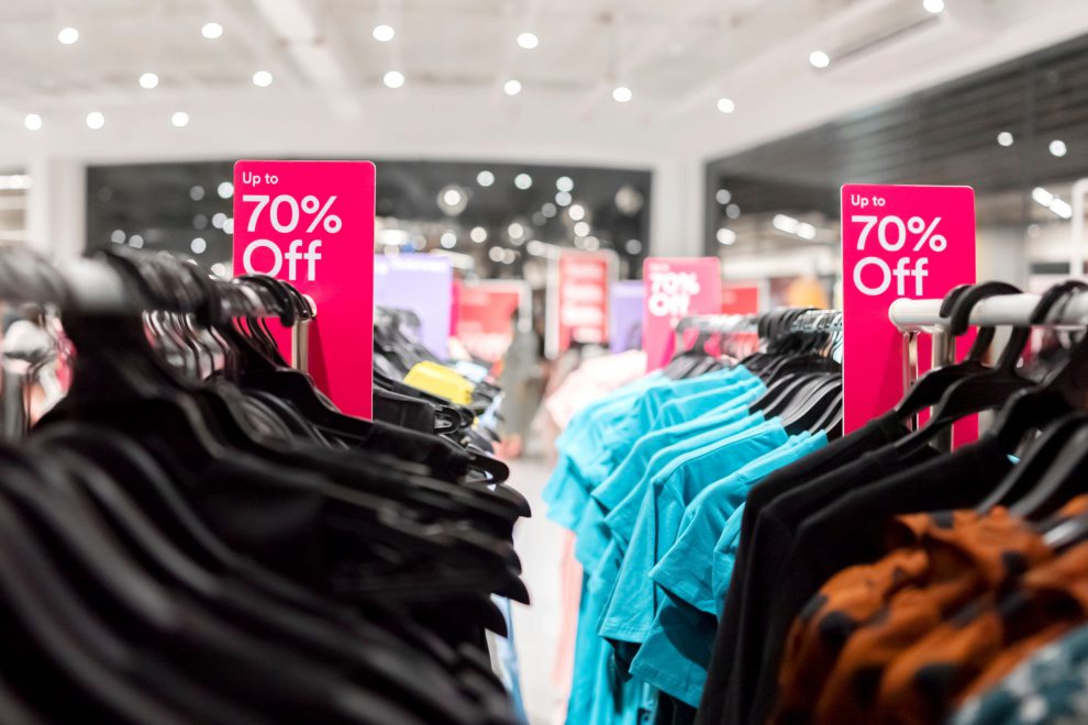 Shoppen in der Krise: Kleidung wird in einem Laden mit großen Rabatt angeboten. Symbolbild für das Wörterbuch der Inflation.