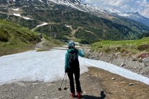 EineSkifahrerin steht vor einem geschmolzenen Gletscher. Der Klimawandel ist daran Schuld.