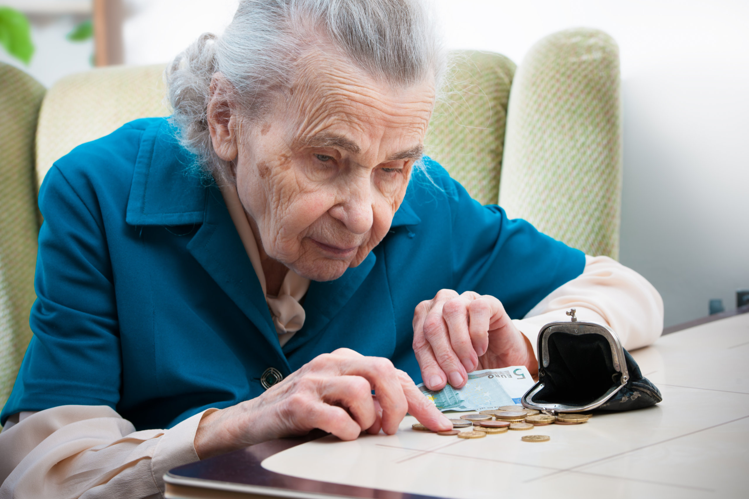 Eine ältere Frau zählt ihr Kleingeld. Sie ist in der Pension auf jeden Cent angewiesen.