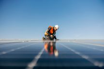 Mann arbeitet an einer Photovoltaikanlage. Symbolbild für die Erneuerbare Energie.