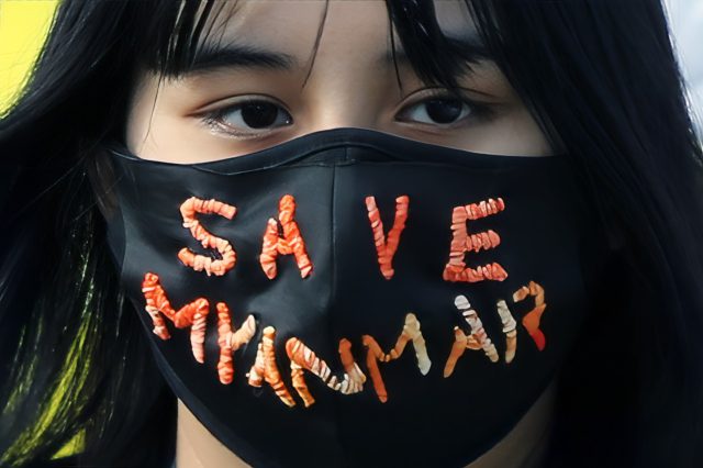 Eine Frau trägt eine Maske mit der Aufschrift "Save Myanmar". Symbolbild für den Widerstand von Khaing Zar Aung.