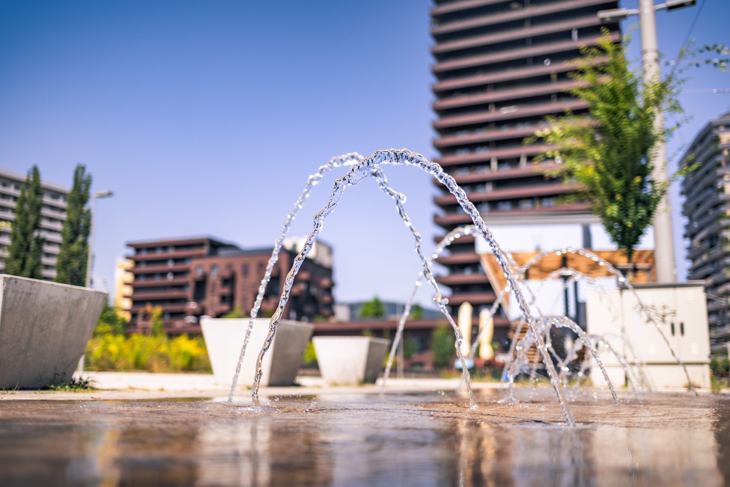 Das Stadtentwicklungsgebiete Reininghaus wird für den Klimaschutzplan Graz umgebaut. Zu sehen sind Wasserspiele vor den Wohnhäusern.