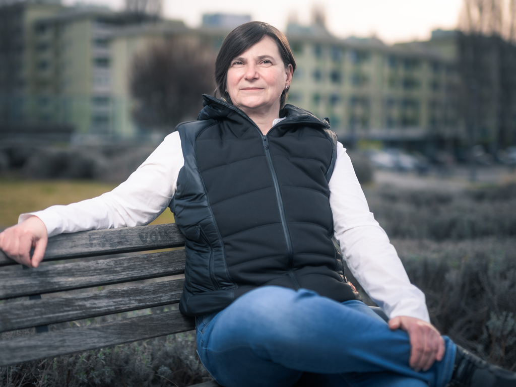 Portrait Ökonomin Angela Pfister auf einer Parkbank beim Interview zum Thema Wohnkosten.