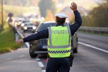 Ein Polizist aus Österreich winkt ein Auto heraus. Die GÖD plant in der Herbstlohnrunde 2024 Kampfmaßnahmen im öffentlichen Dienst.