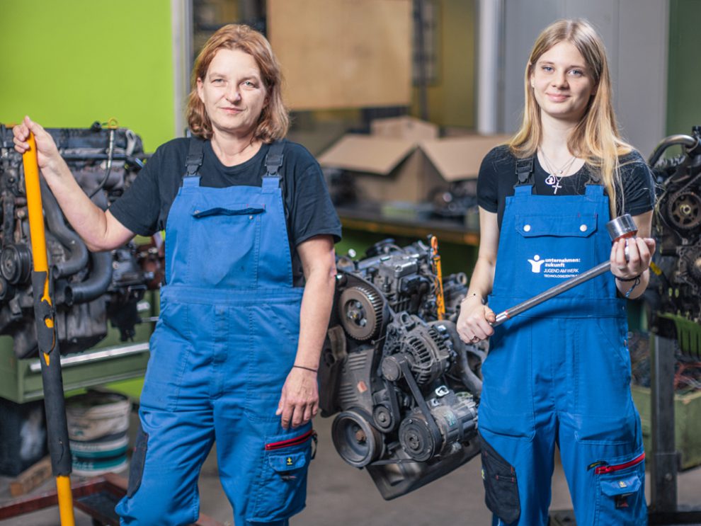 Gabriele Ertl und Chelsea Möstl stehen in der Lehrwerkstatt Jugend am Werk nebeneinander.