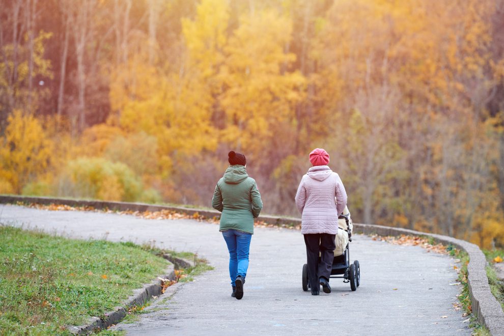 Zwei Frauen auf einem Spaziergang. Eine Frau schiebt einen Kinderwagen. Symbolbild für die Prognose für die Sozialpolitik.