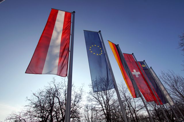 Verschiedene Flaggen sind zu sehen. Im Vordergrund sind die Österreich-Flagge und die EU-Flagge. Symbolbild für den EU-Betritt Österreichs.